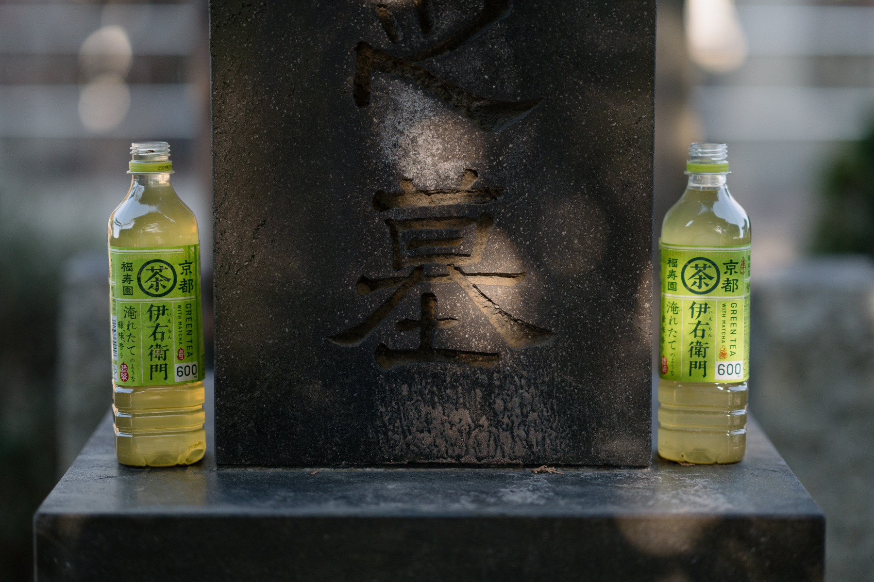 <span style="color: rgb(0, 0, 0);">Open bottles of green tea placed at a family grave. Flowers, drinks, or memorabilia are often placed at graves, either in remembrance or as an offering.</span>