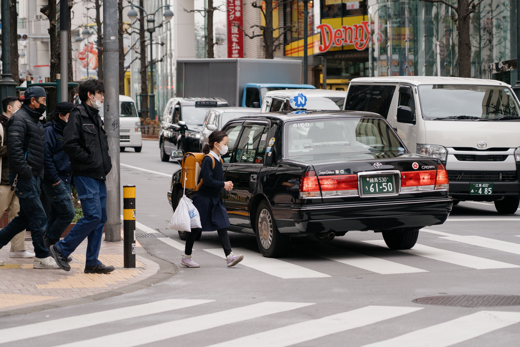 <span style="color: rgb(0, 0, 0);">A student with her </span><em style="color: rgb(0, 0, 0);">randoseru</em><span style="color: rgb(0, 0, 0);"> (standard elementary school backpack) and other bags, walking in Tokyo. It is common to see students commuting by themselves to school and after-school activities, even from a young age.</span>