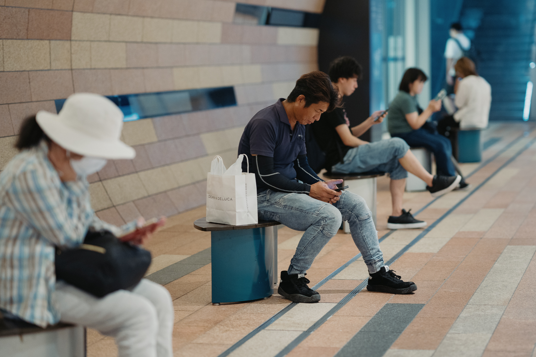 <span style="color: rgb(0, 0, 0);">People sitting and taking a midday break, all on their phones.</span>