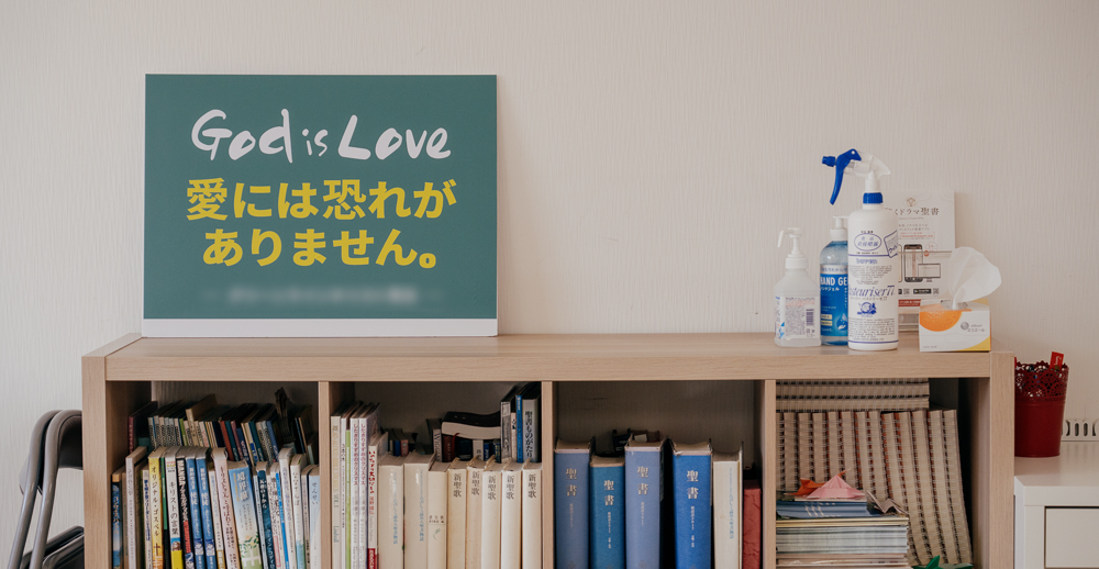 A bookshelf at a church, with a sign that says, "God is Love. There is no fear in love."